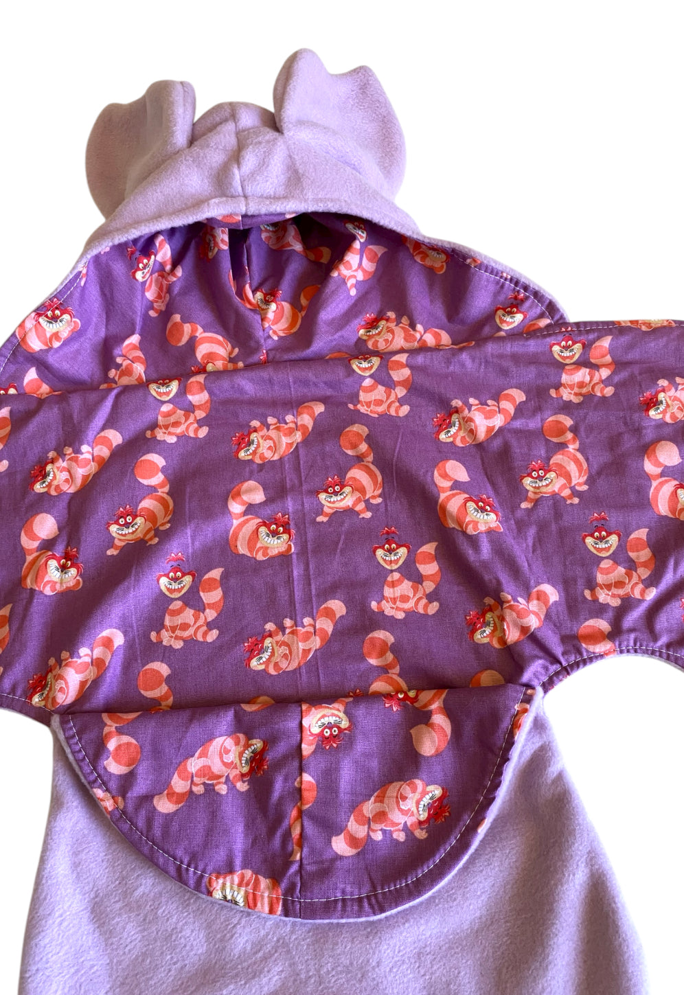 Hooded baby blanket with pink cartoon characters on a purple background