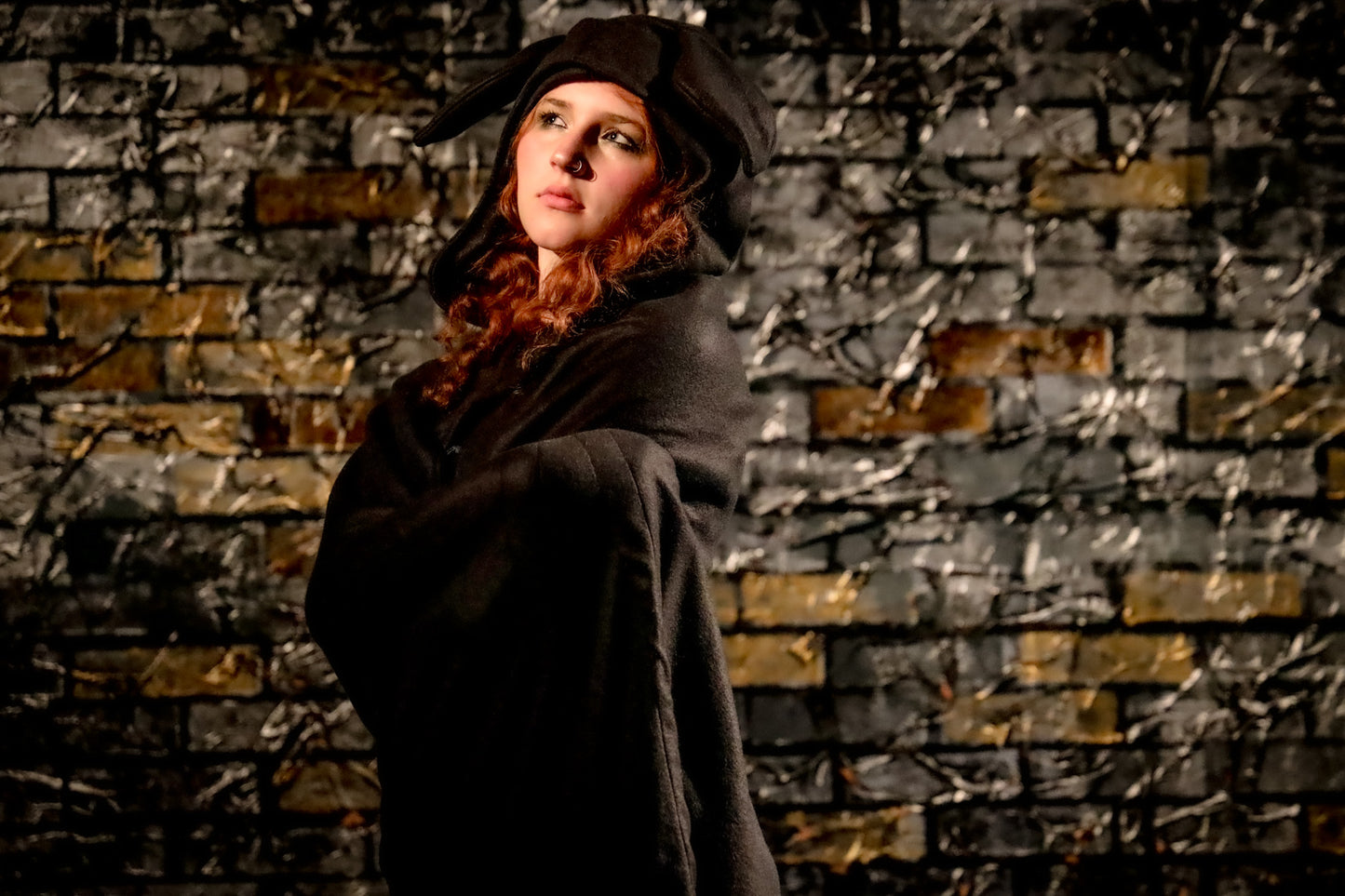 Person in dark clothing against a textured brick wall