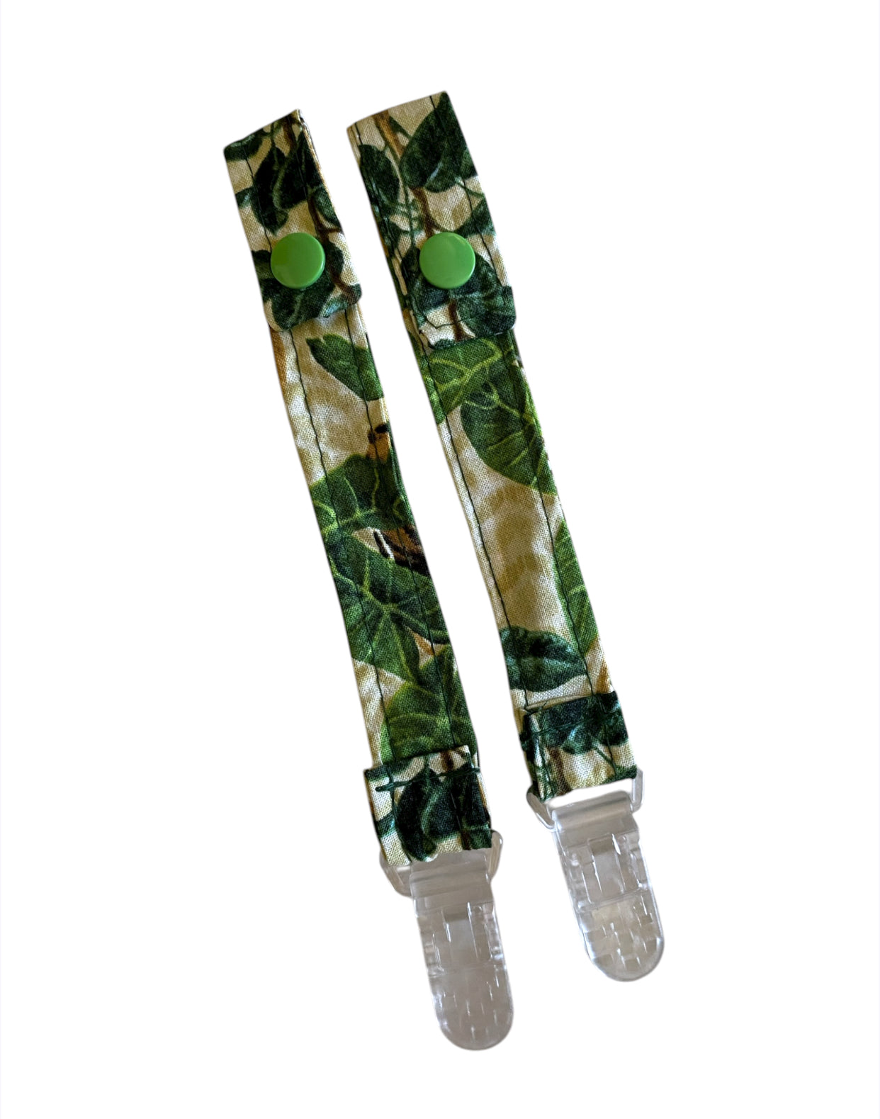 leaf-patterned pacifier clips on white background
