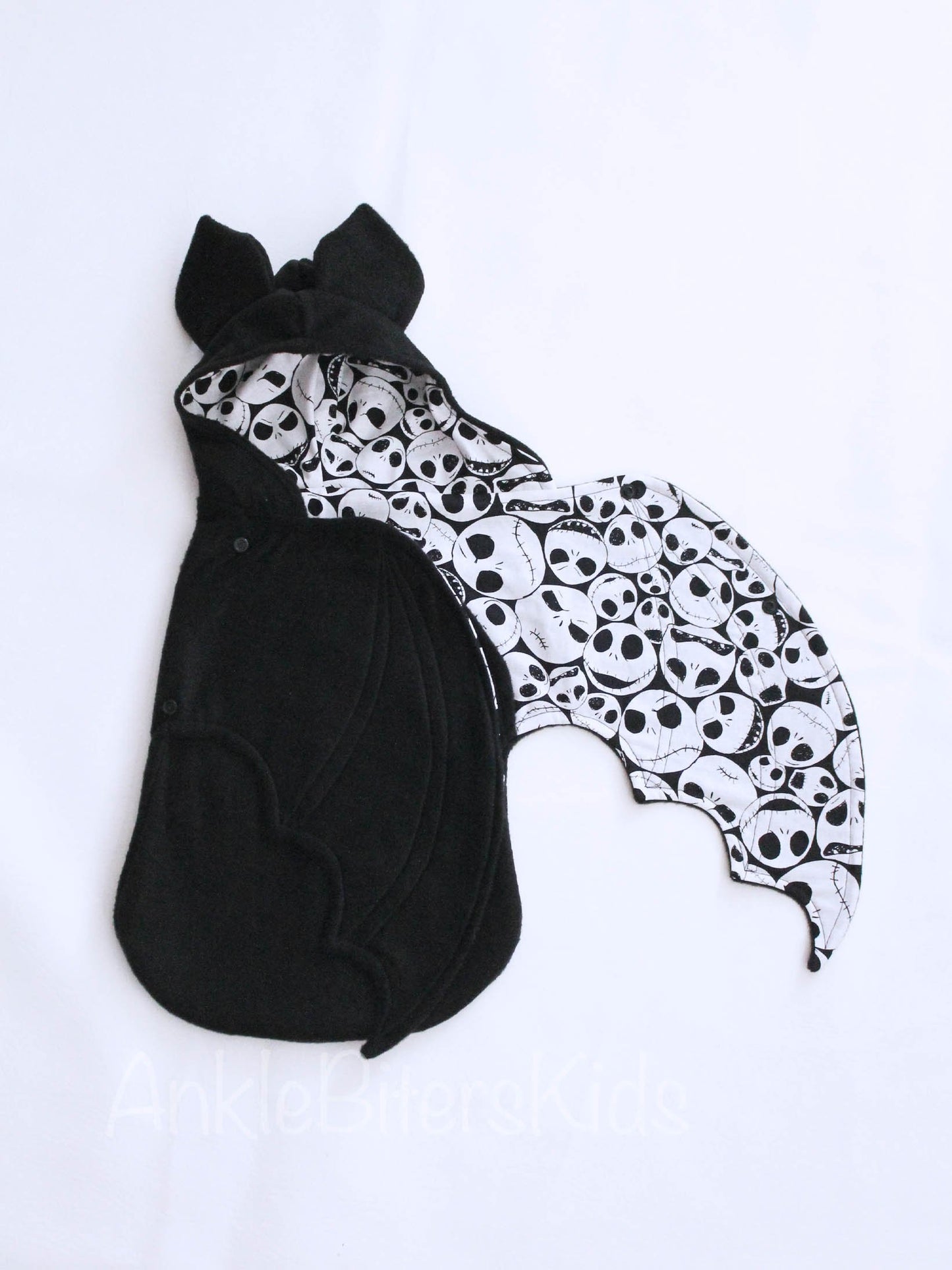 Black and white patterned bat-shaped blanket on a white background