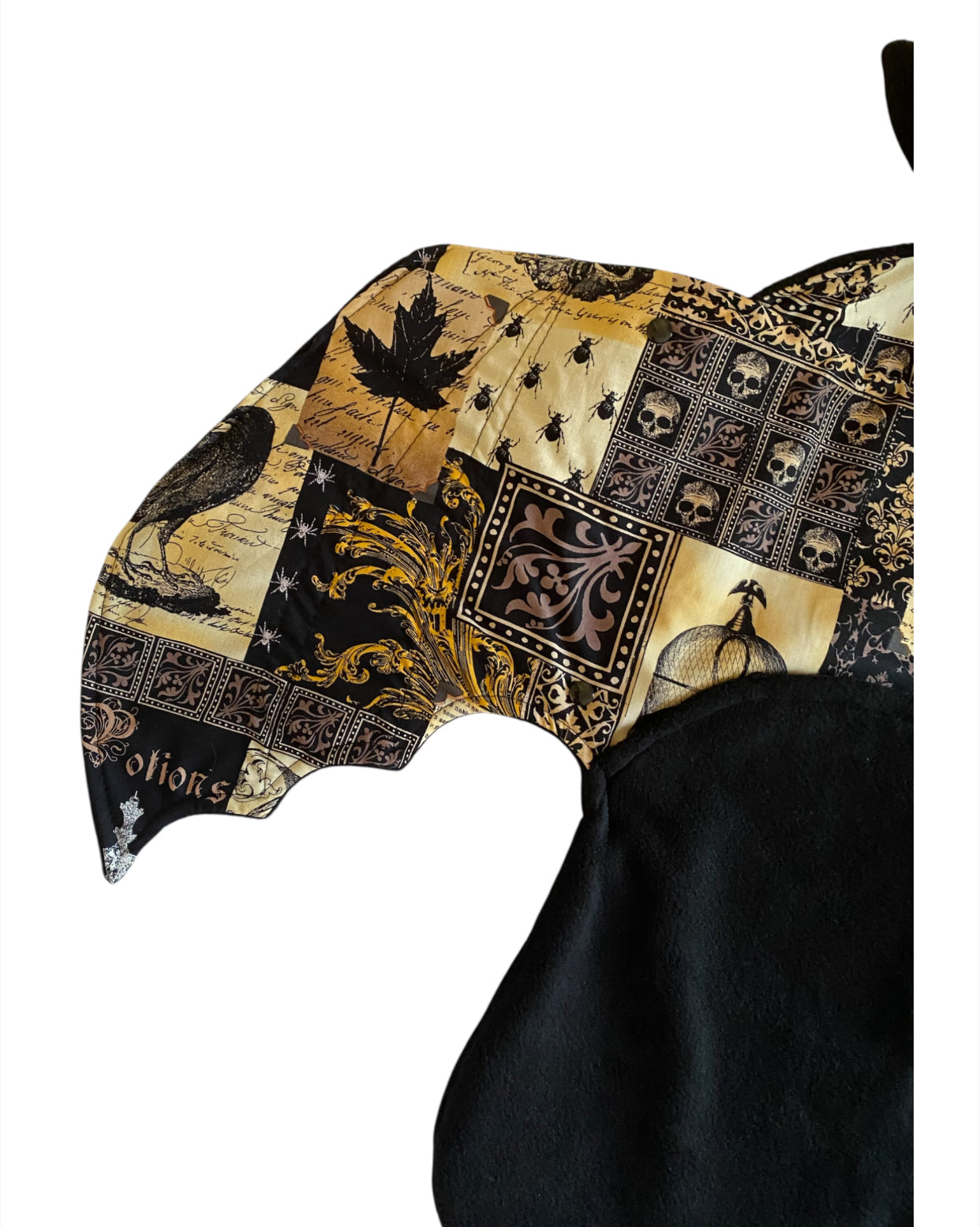 bat wing with gold and black details on white background