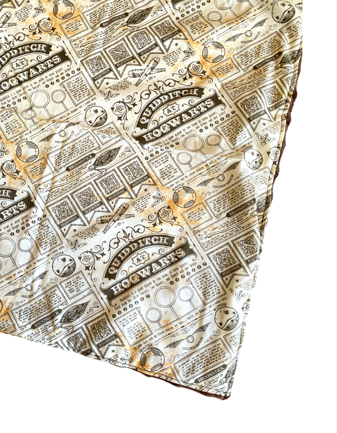 Patterned fabric with 'Quidditch Hogwarts' text and logos on a white background