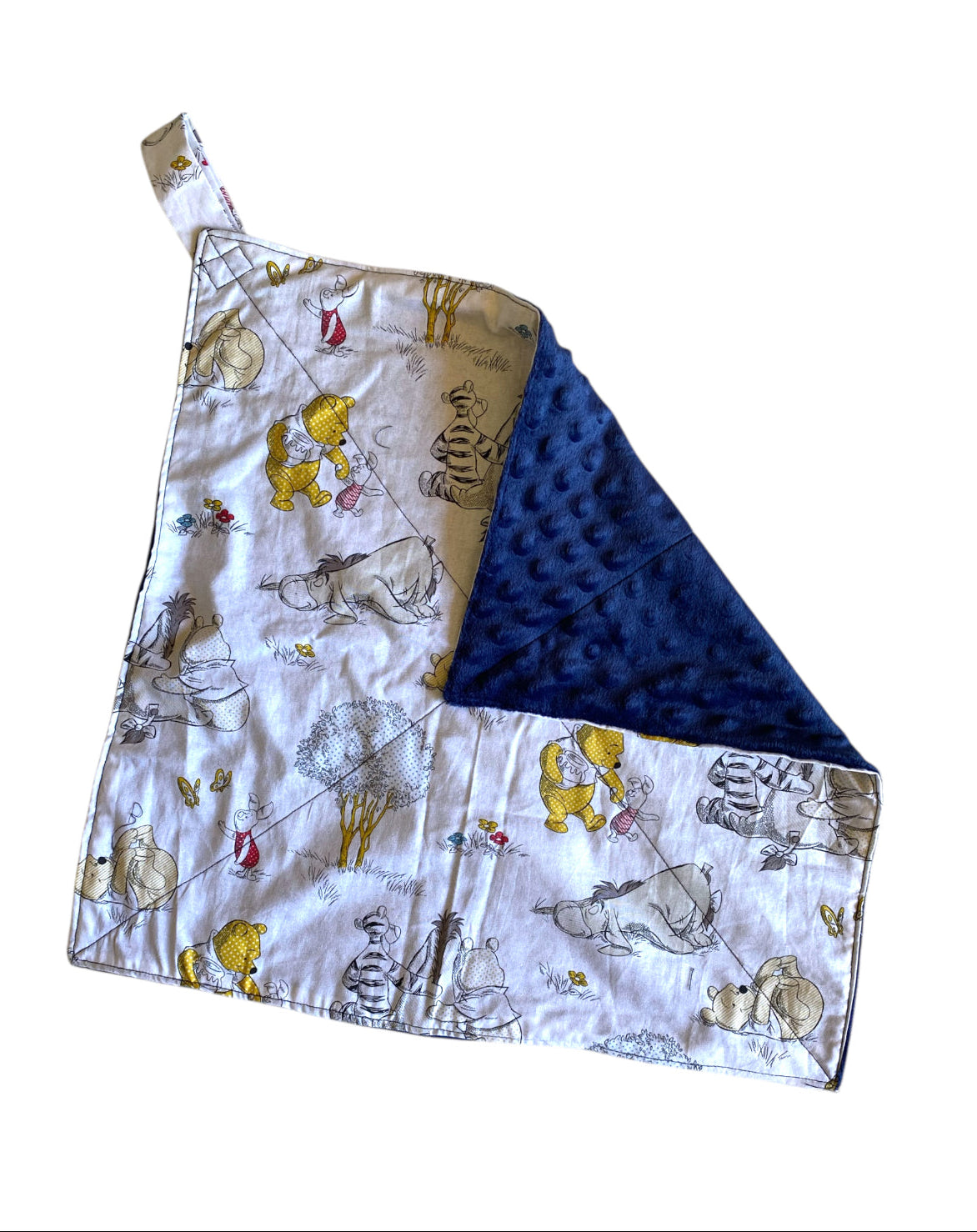 Baby blanket with Winnie the Pooh on one side and blue polka dot pattern on the other, folded on a white background.