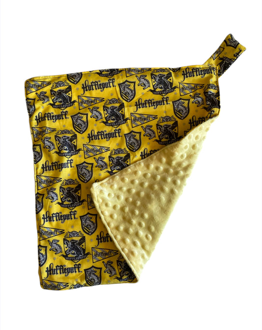 Folded fabric with 'Hufflepuff' pattern on a yellow background