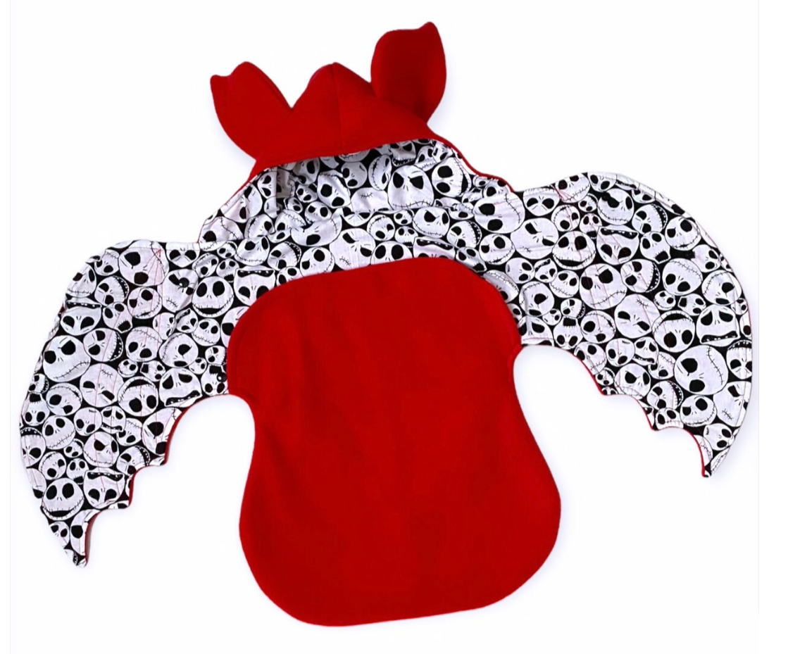 Red and black and white skeleton patterned bat blanket on a white background