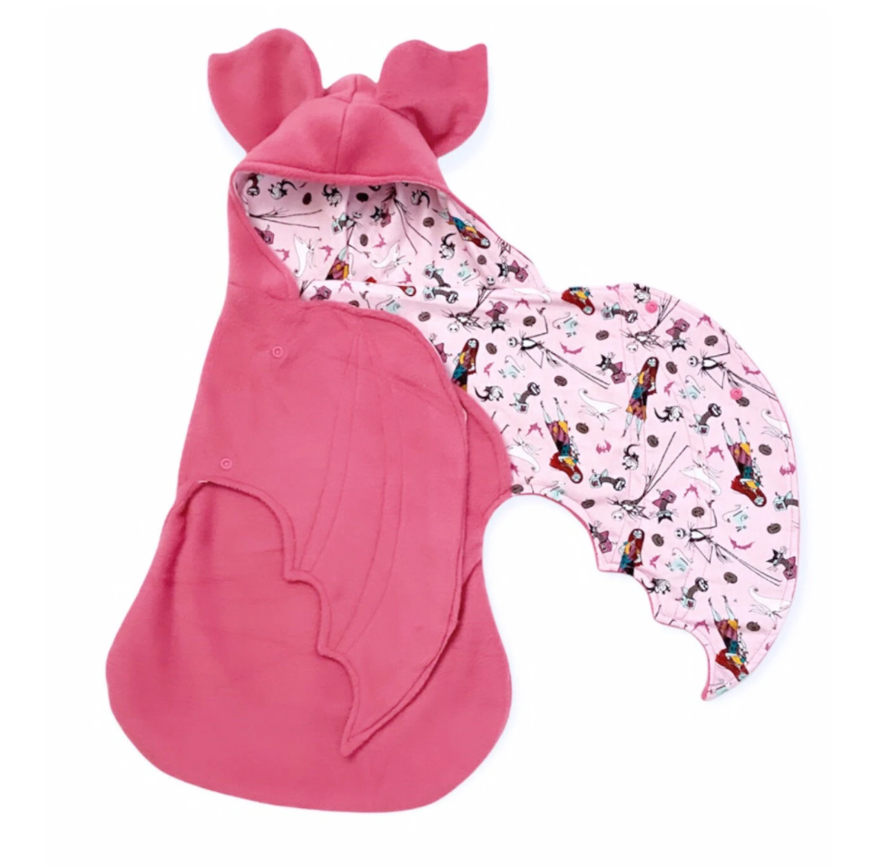 Pink baby swaddle with cartoon character pattern on a white background