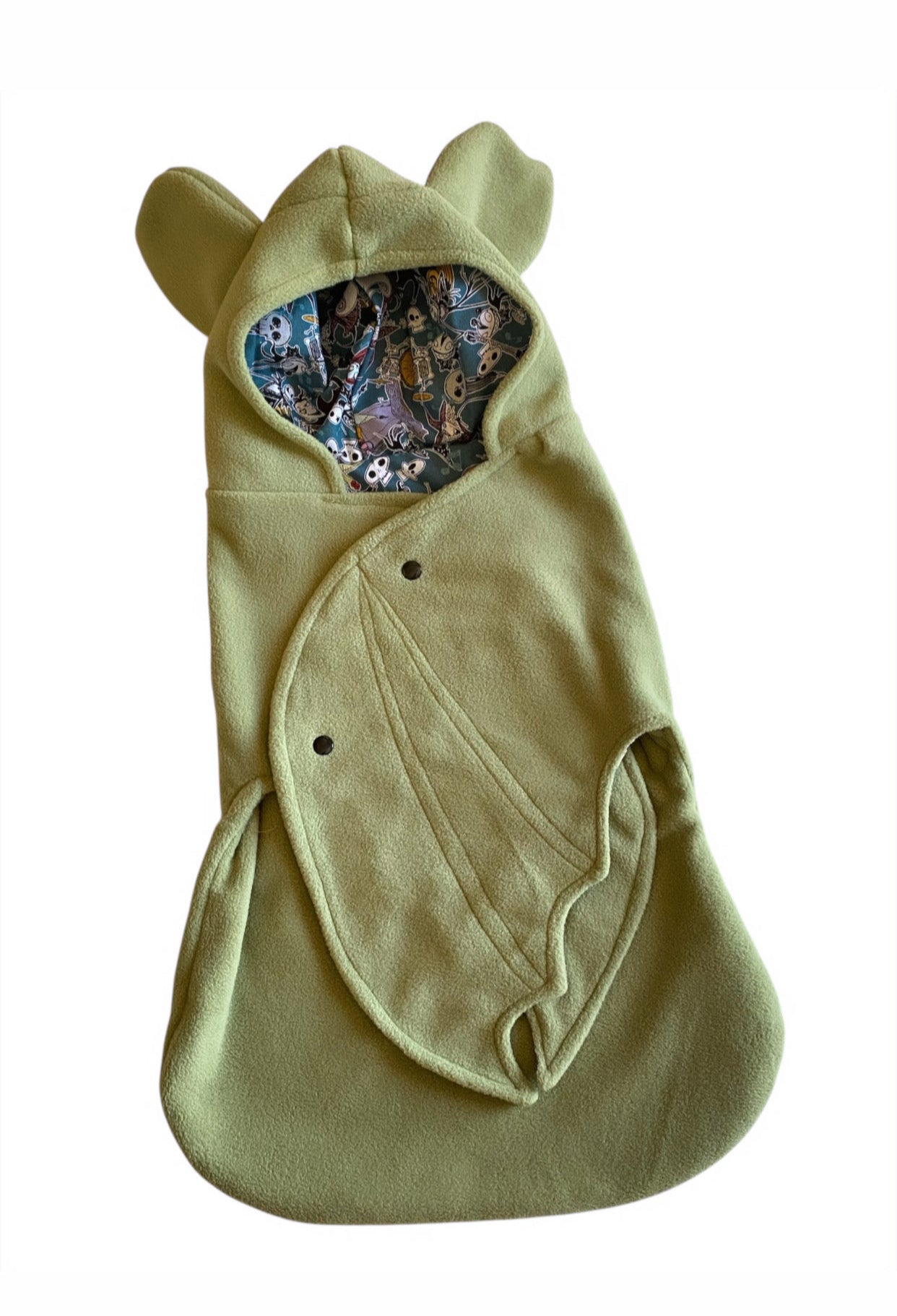 Green baby wrap with bat ears and pattern on a white background